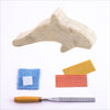 Contents of Studiostone Creative's soapstone orca making kit including: Sandpaper, wax, cloth, file and soapstone orca shape | Conscious Craft